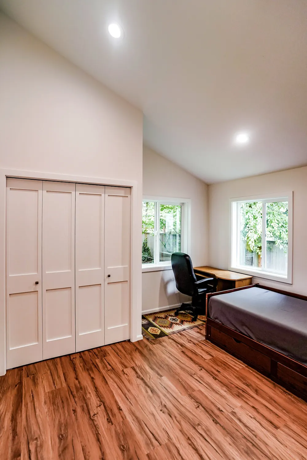 Bedroom with a vaulted ceiling and wood floors