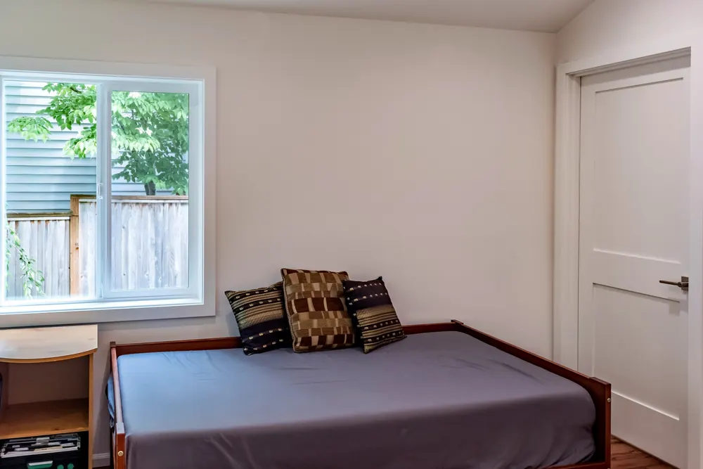 Bedroom with a daybed and wood flooring