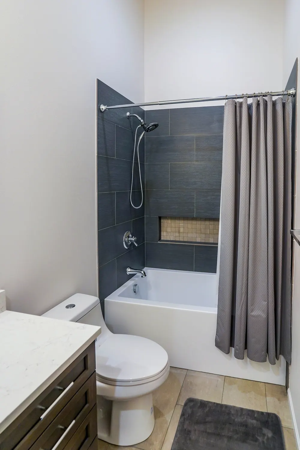 Bathroom with a tub-shower, vanity and toilet