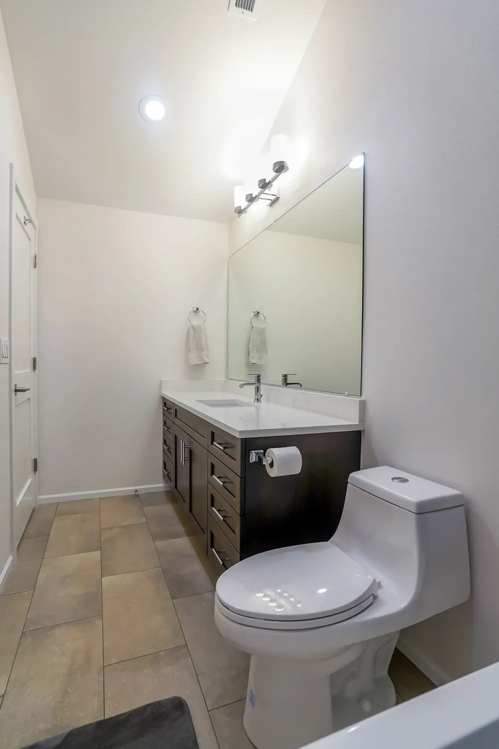 Small bathroom with a vanity, mirror and one-piece toilet