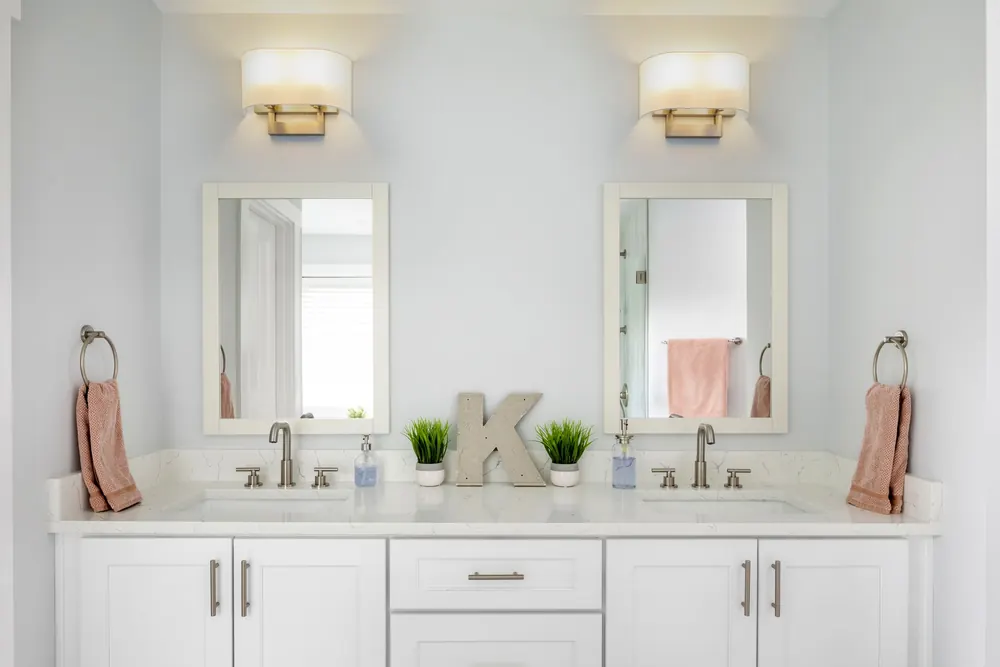 Double vanity with two mirrors and wall sconces