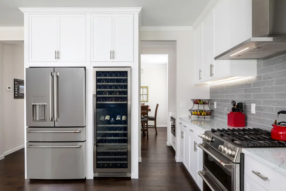 Kitchen with a stainless refrigerator, wine fridge and range hood
