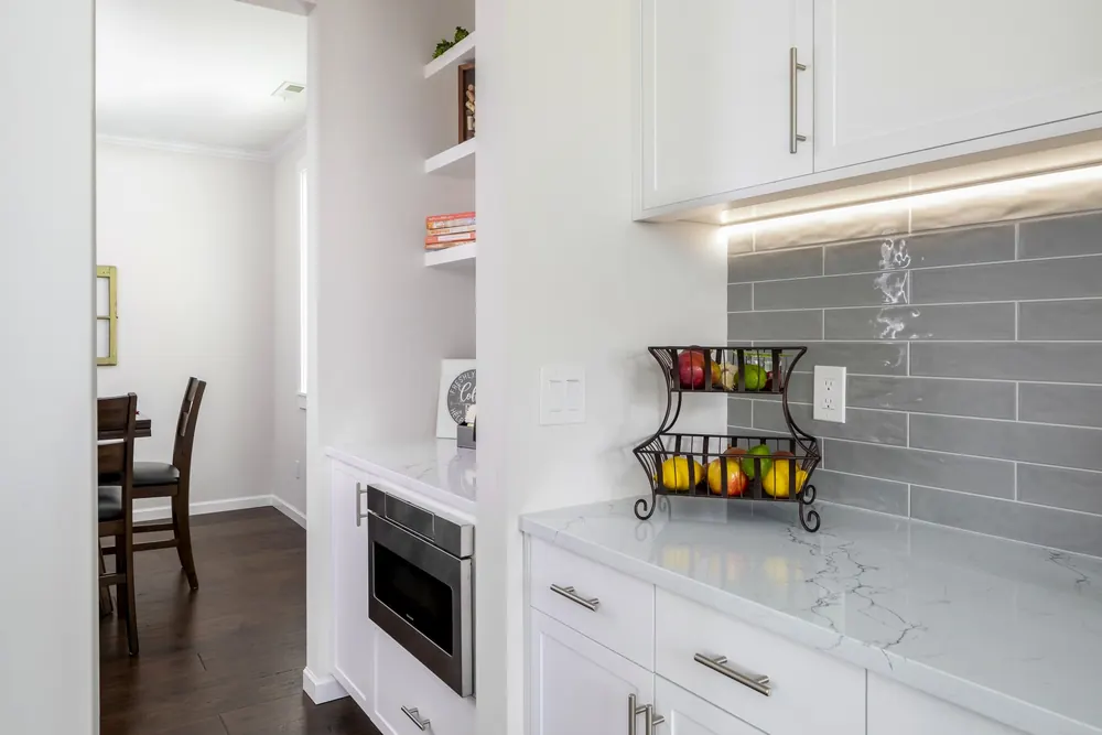 Kitchen corner with open shelves and gray subway backsplash