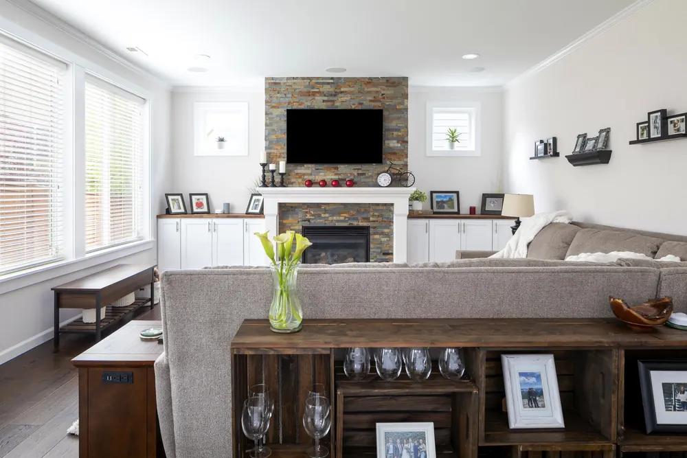 Living room with a stacked-stone fireplace and built-in cabinets