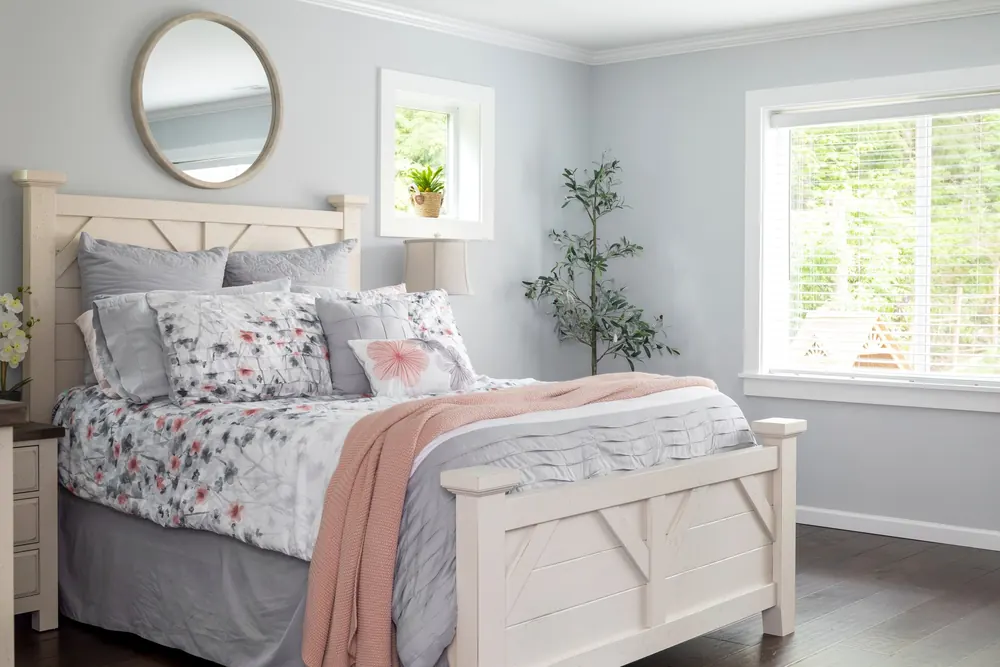 Bedroom with a round mirror and white furniture