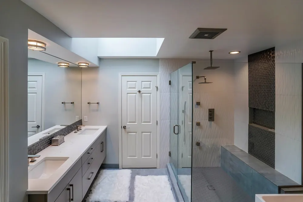Bathroom with a skylight, long vanity and glass-enclosed shower