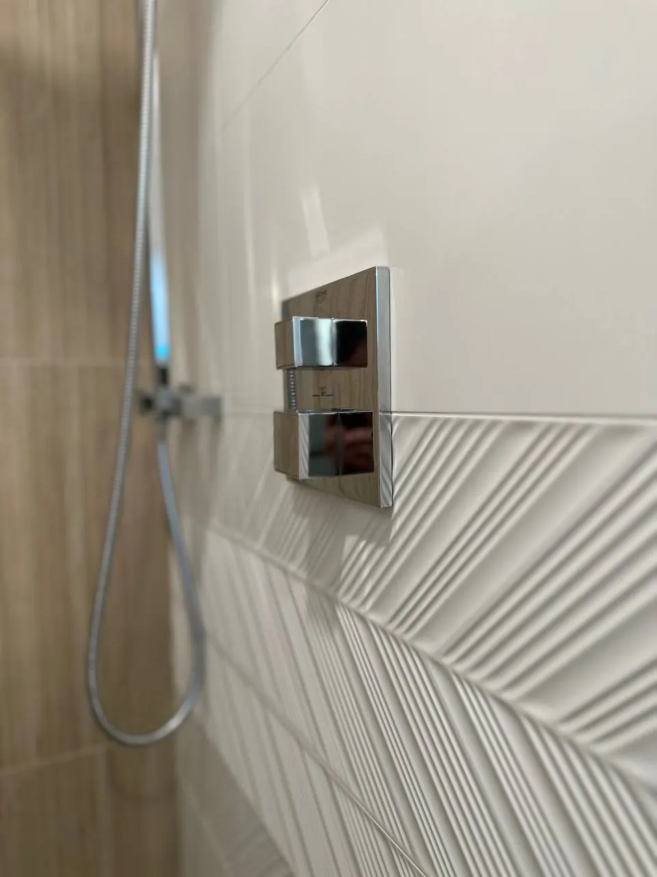 Shower valve on white feather-pattern tile