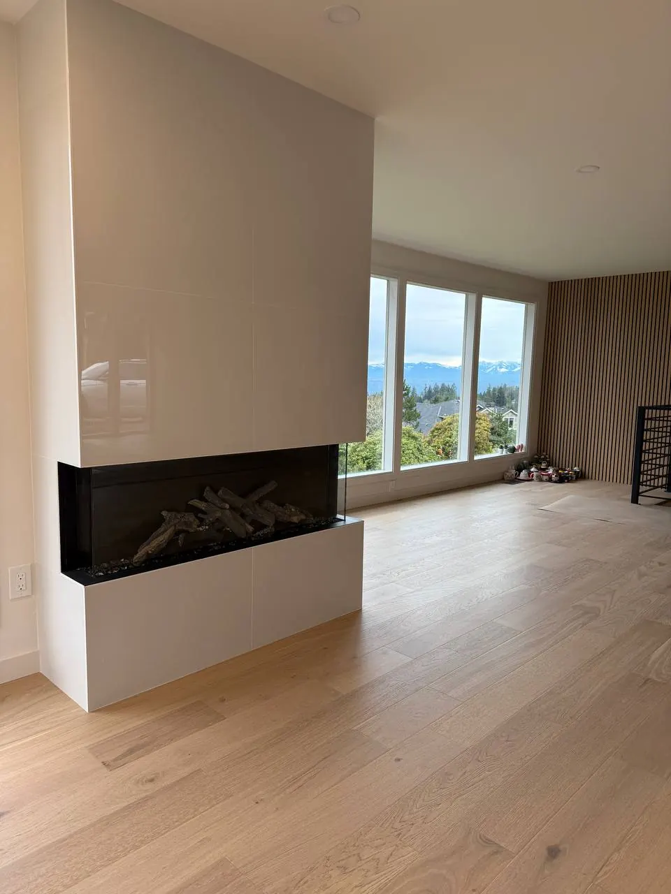 Fireplace wall in a bright room with wide-plank wood floors