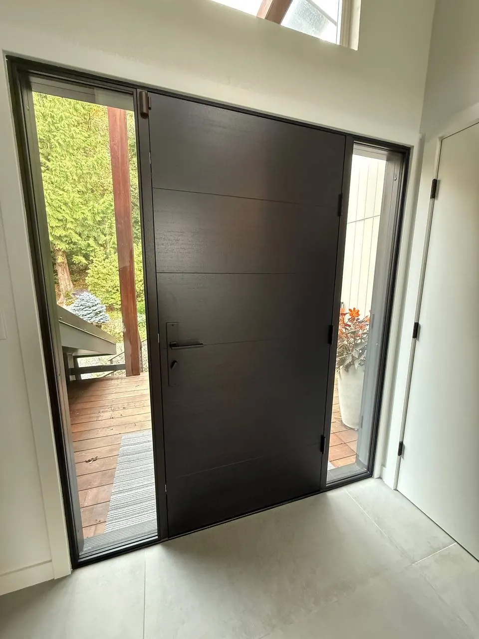 Black front door with a glass sidelight