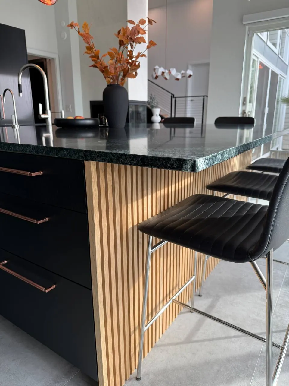 Island seating with wood-slat panels and black stools