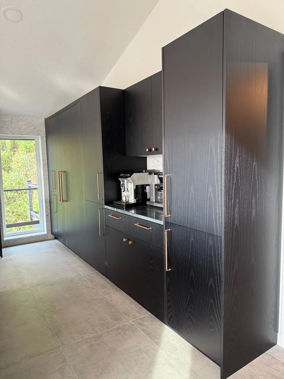 Black wood-grain tall cabinets with a coffee station