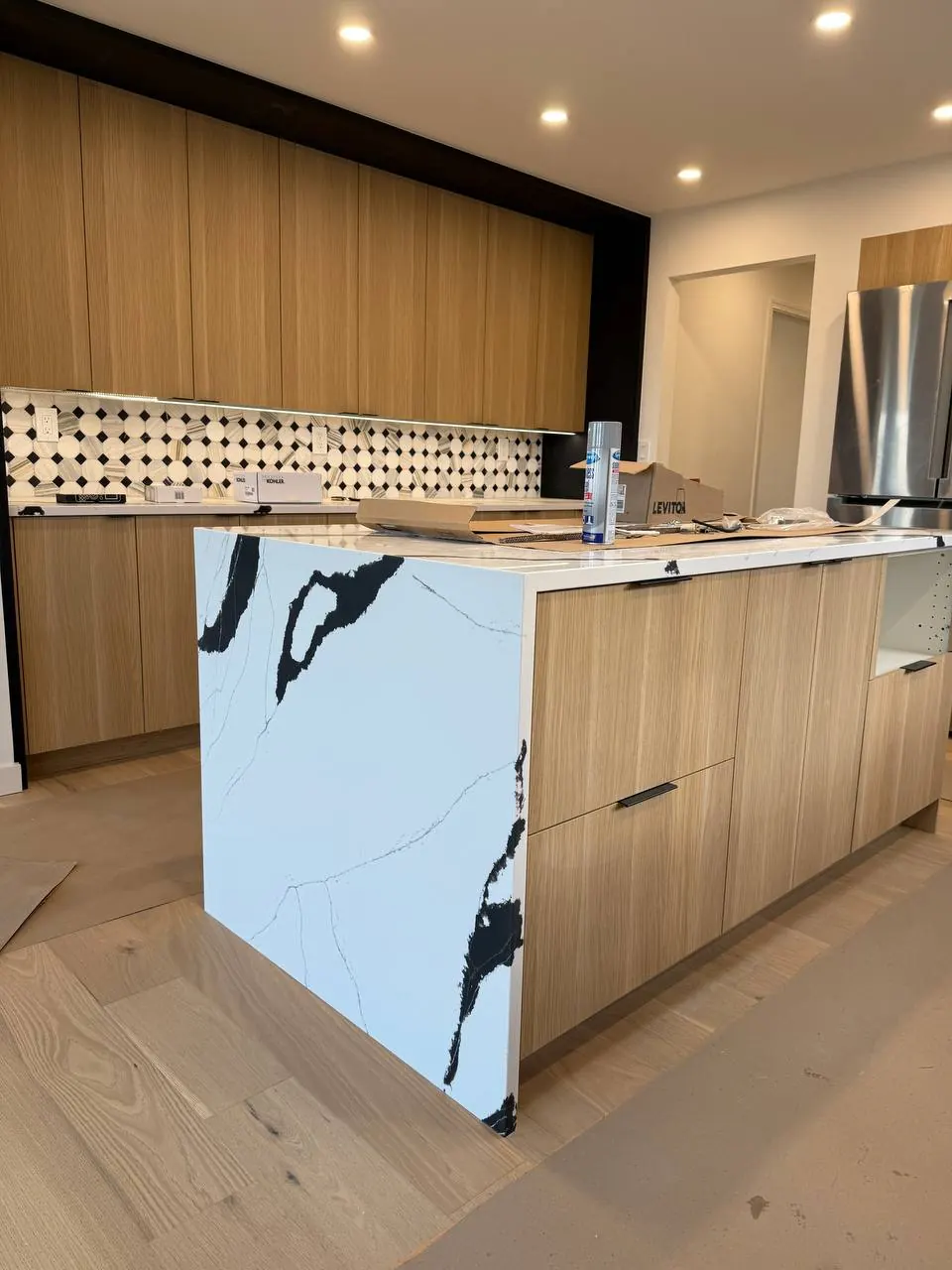 Wood kitchen with a black-and-white veined waterfall island