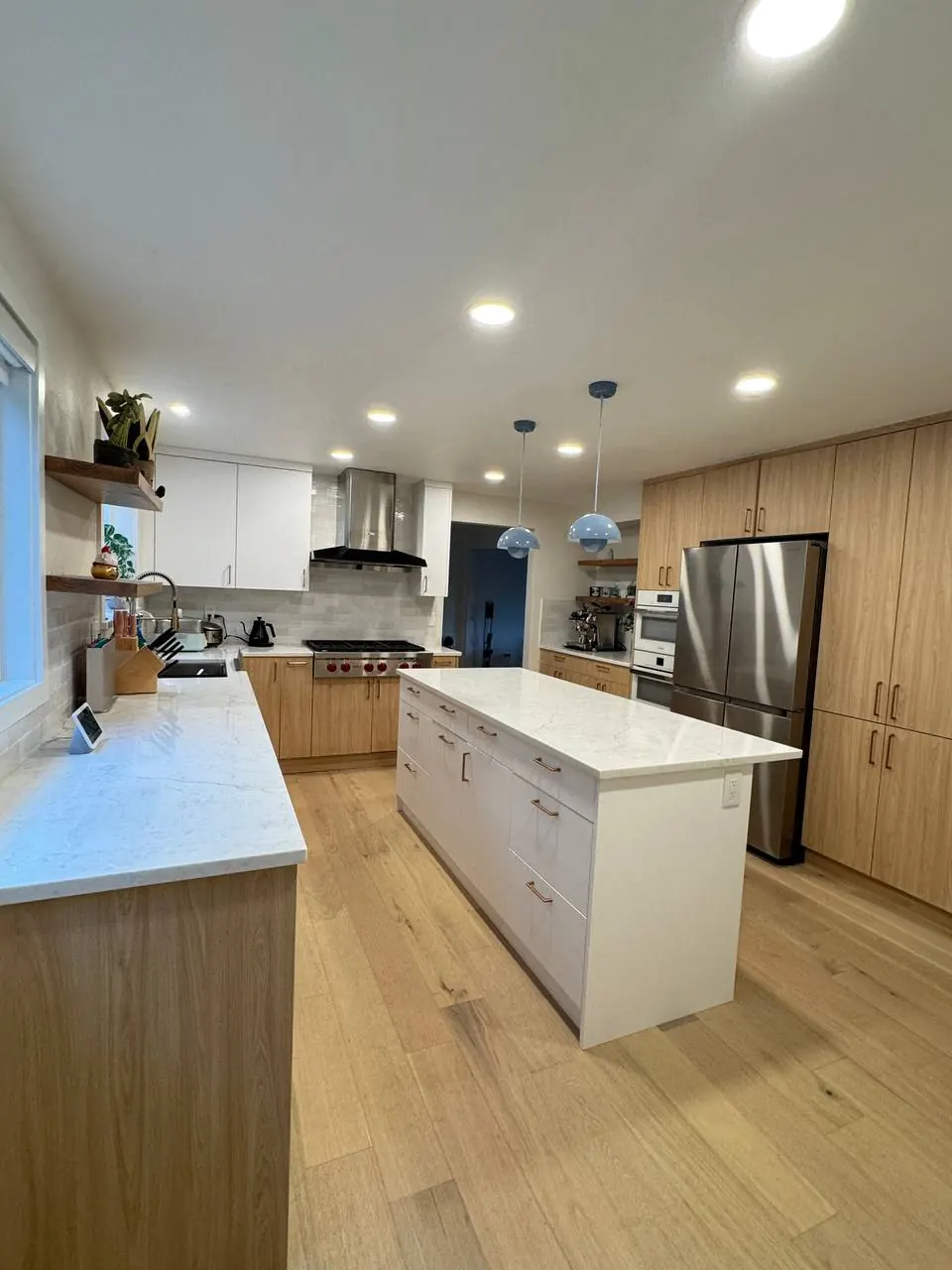 Kitchen with a white island, wood-tone cabinetry and stainless appliances