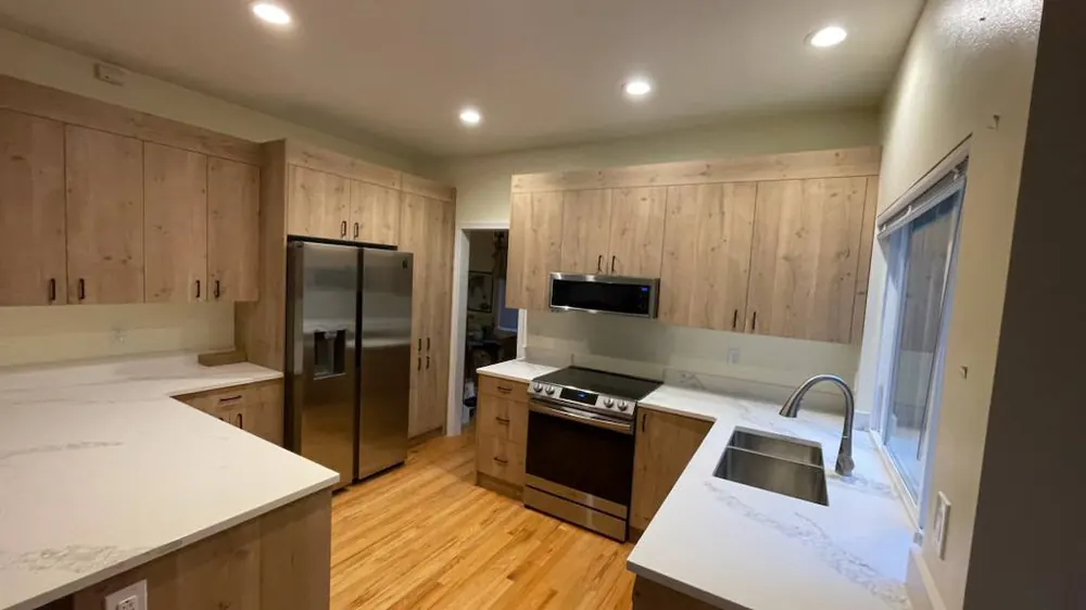 Wood-tone kitchen with white counters and stainless appliances