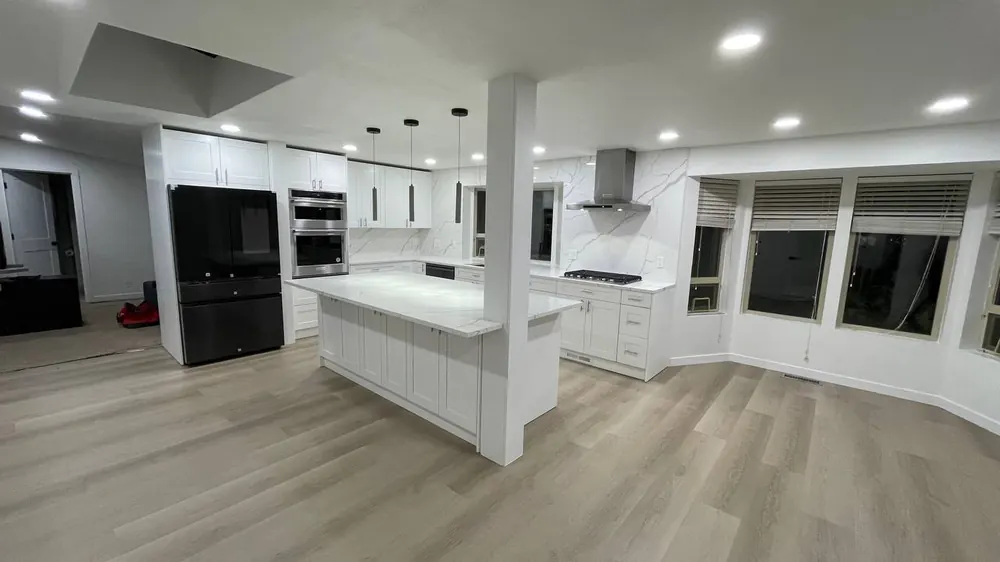 Open white kitchen with an island and bay windows