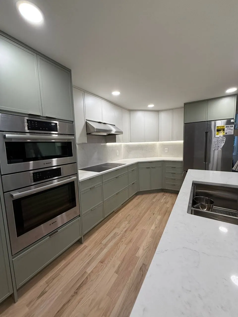 Sage and white kitchen with double wall ovens