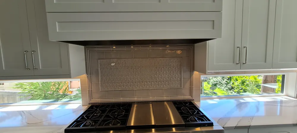 Range hood and backsplash between two windows