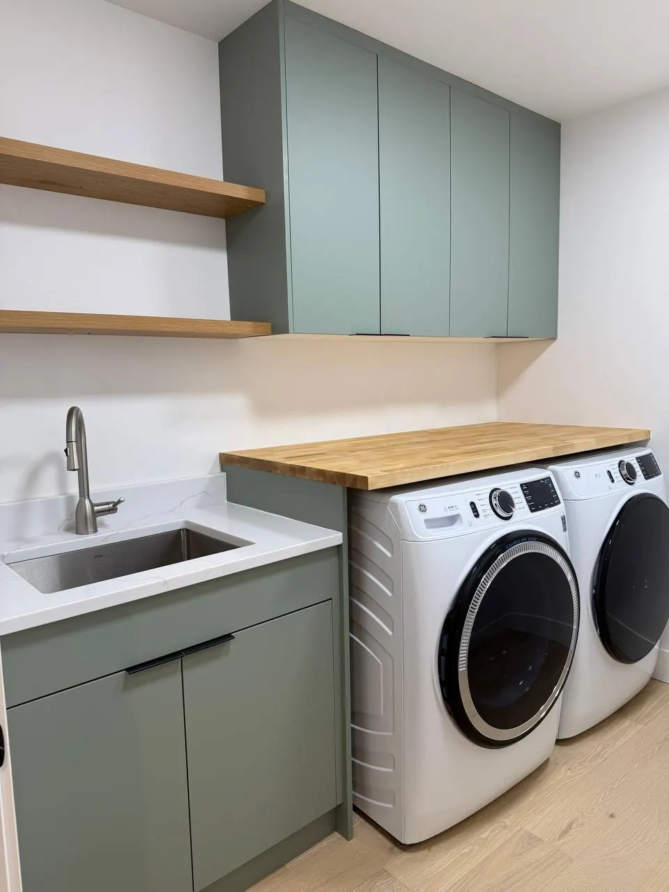 Laundry with sage cabinets, a butcher-block top and utility sink
