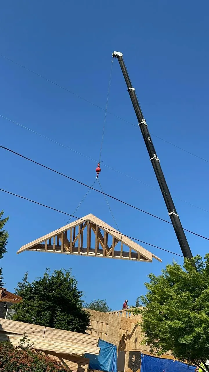 Crane lifting a roof truss into place
