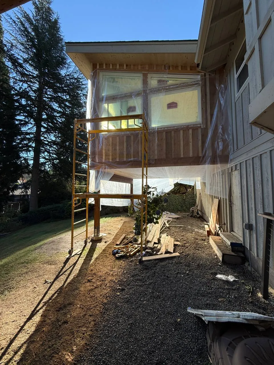 Deck under construction beside a two-story house