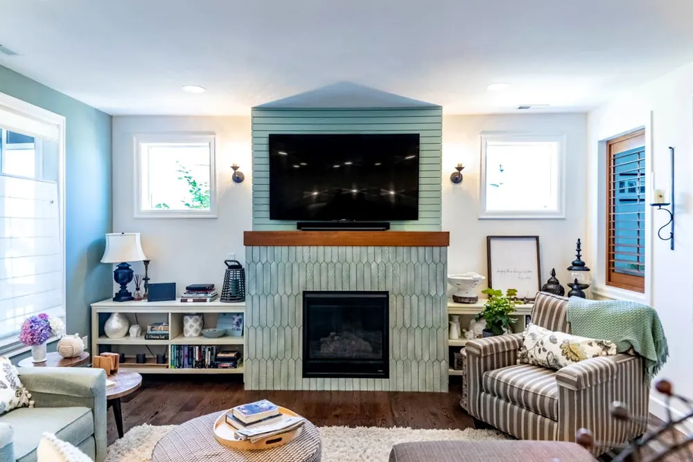 Living room with a tiled fireplace, mounted TV and built-in shelves