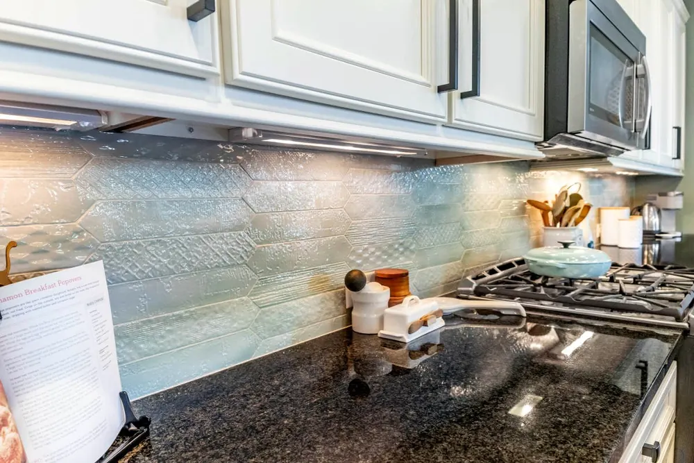 White cabinets, under-cabinet lights and a dark counter