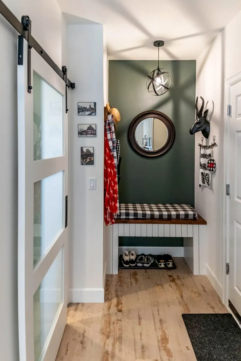 Entry nook with a sliding barn door, bench and wall hooks