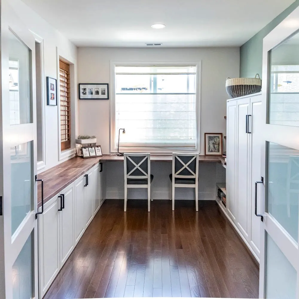 Home office with a built-in desk under the windows