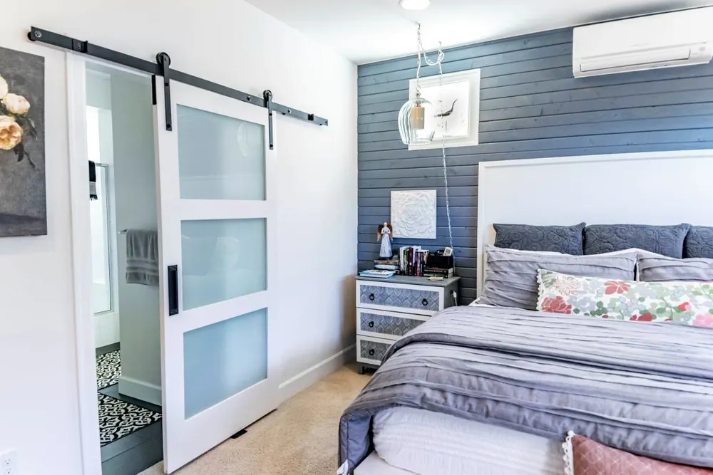 Bedroom with a shiplap accent wall and sliding barn door