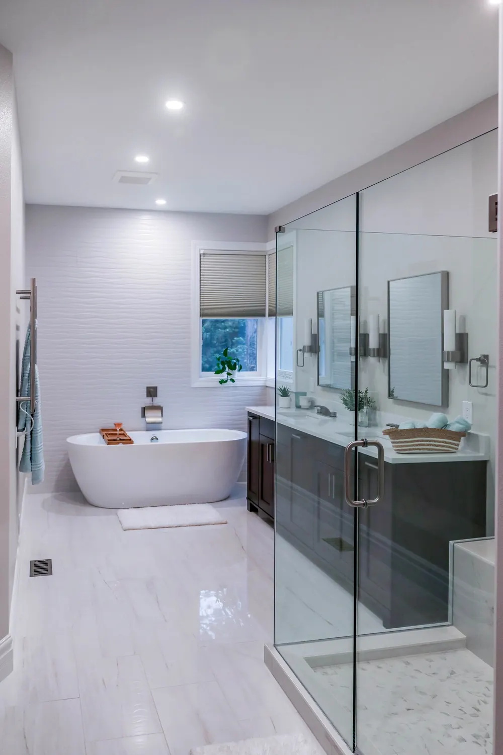 Primary bathroom with a freestanding tub, glass shower and dark vanity