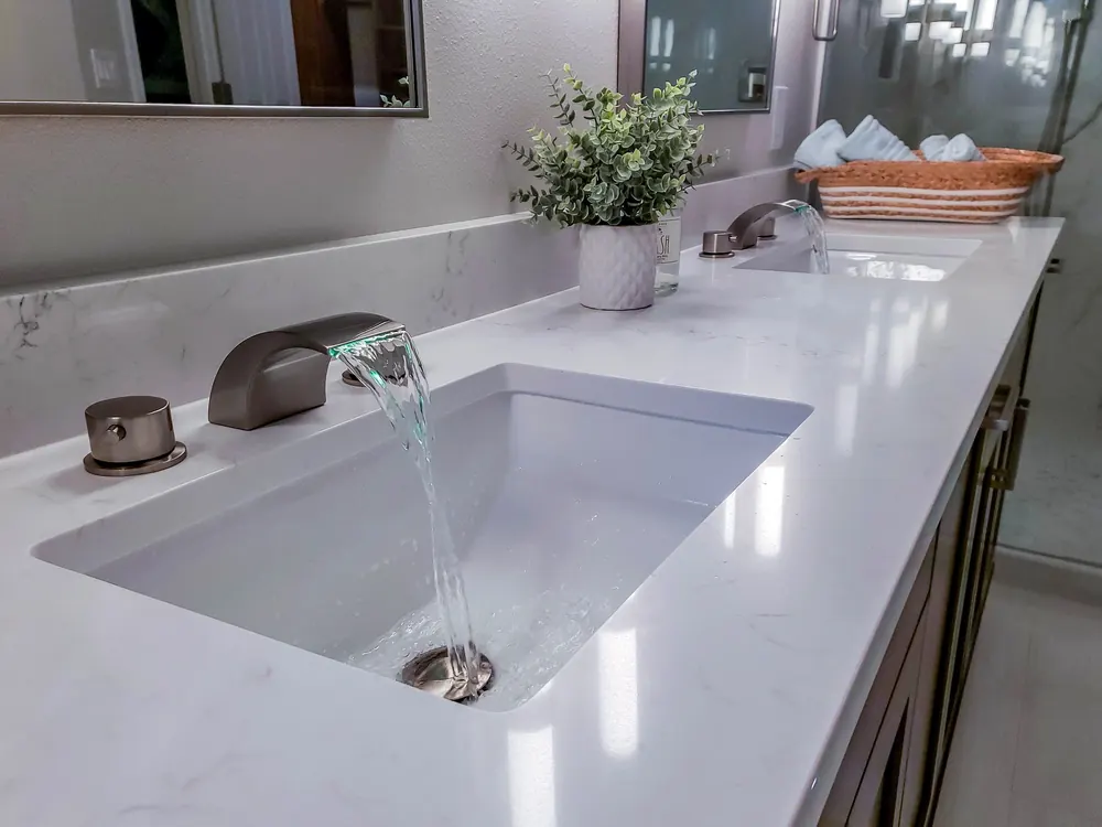 Undermount sink with a bronze faucet on a white counter