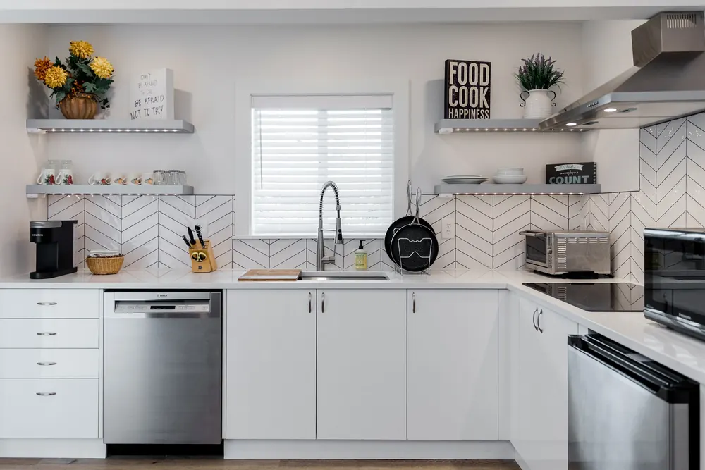 White kitchen with a herringbone backsplash and open shelves