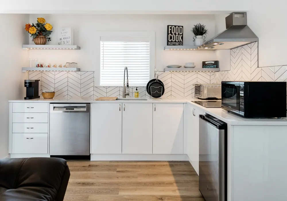 Open kitchen with floating shelves and herringbone tile