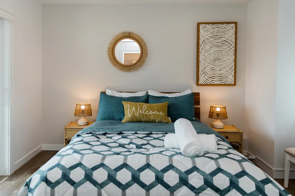 Bedroom with a round mirror and patterned bedding