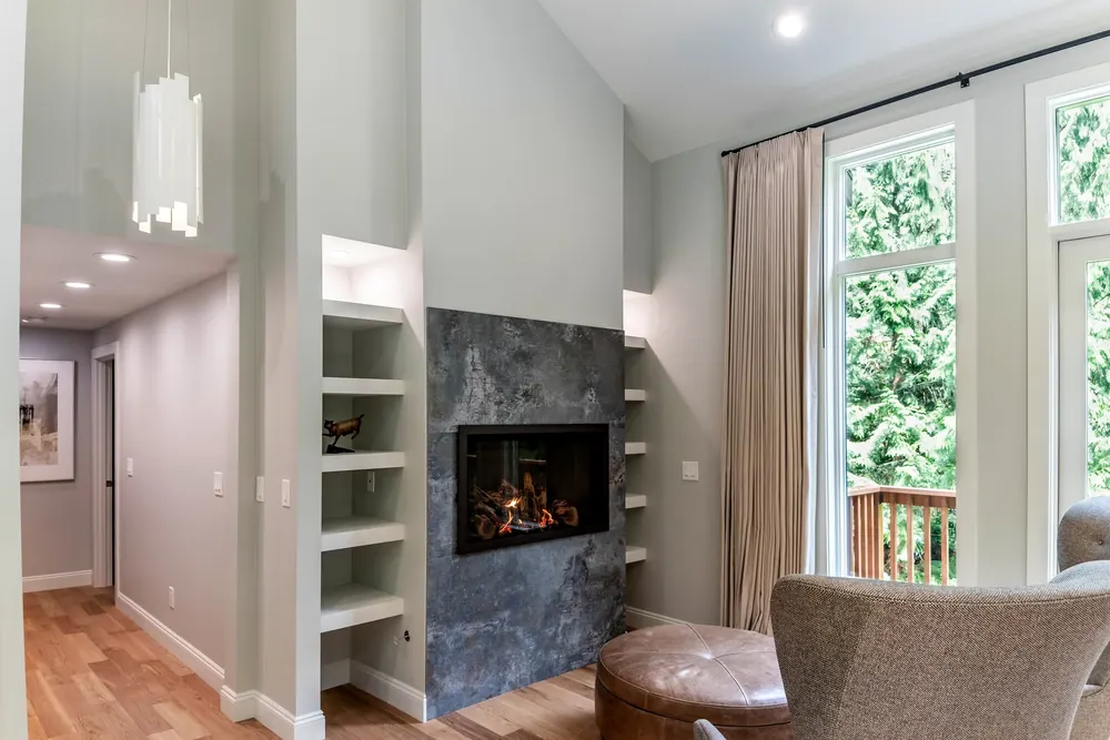 Fireplace with a dark tile surround and built-in shelves