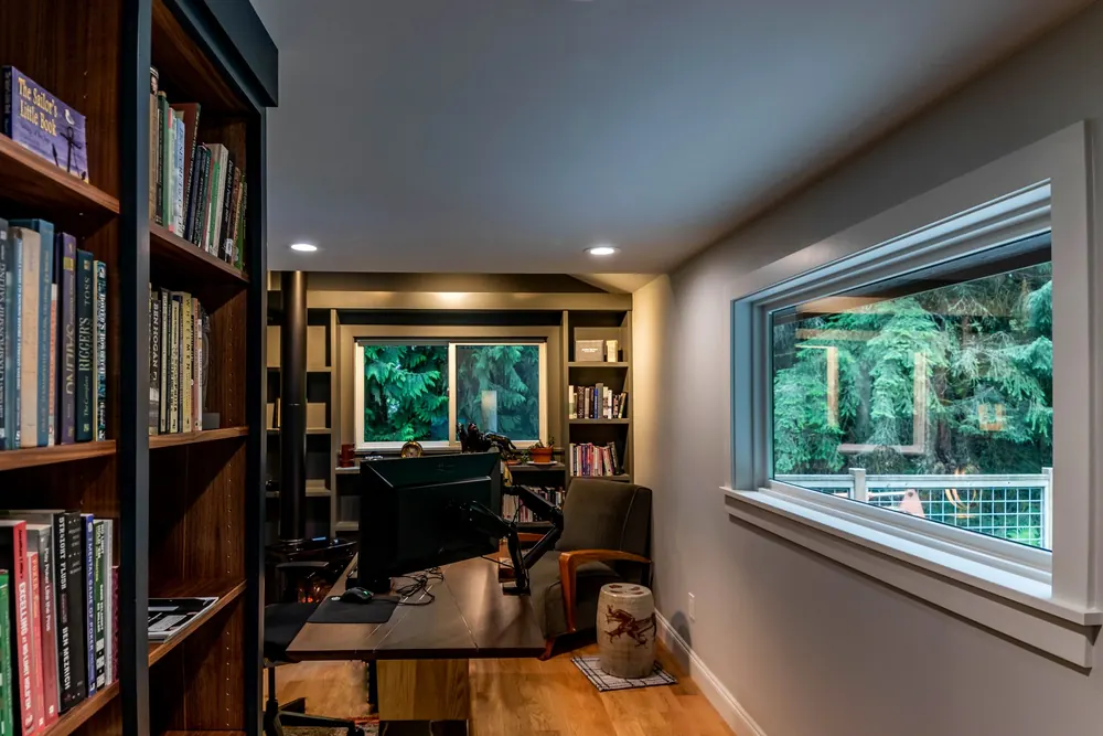 Home library with floor-to-ceiling bookshelves and a wide window