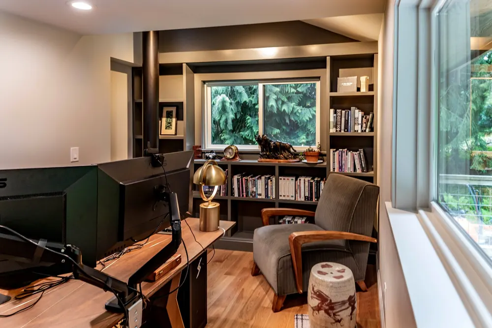 Office corner with bookshelves and a desk by the window