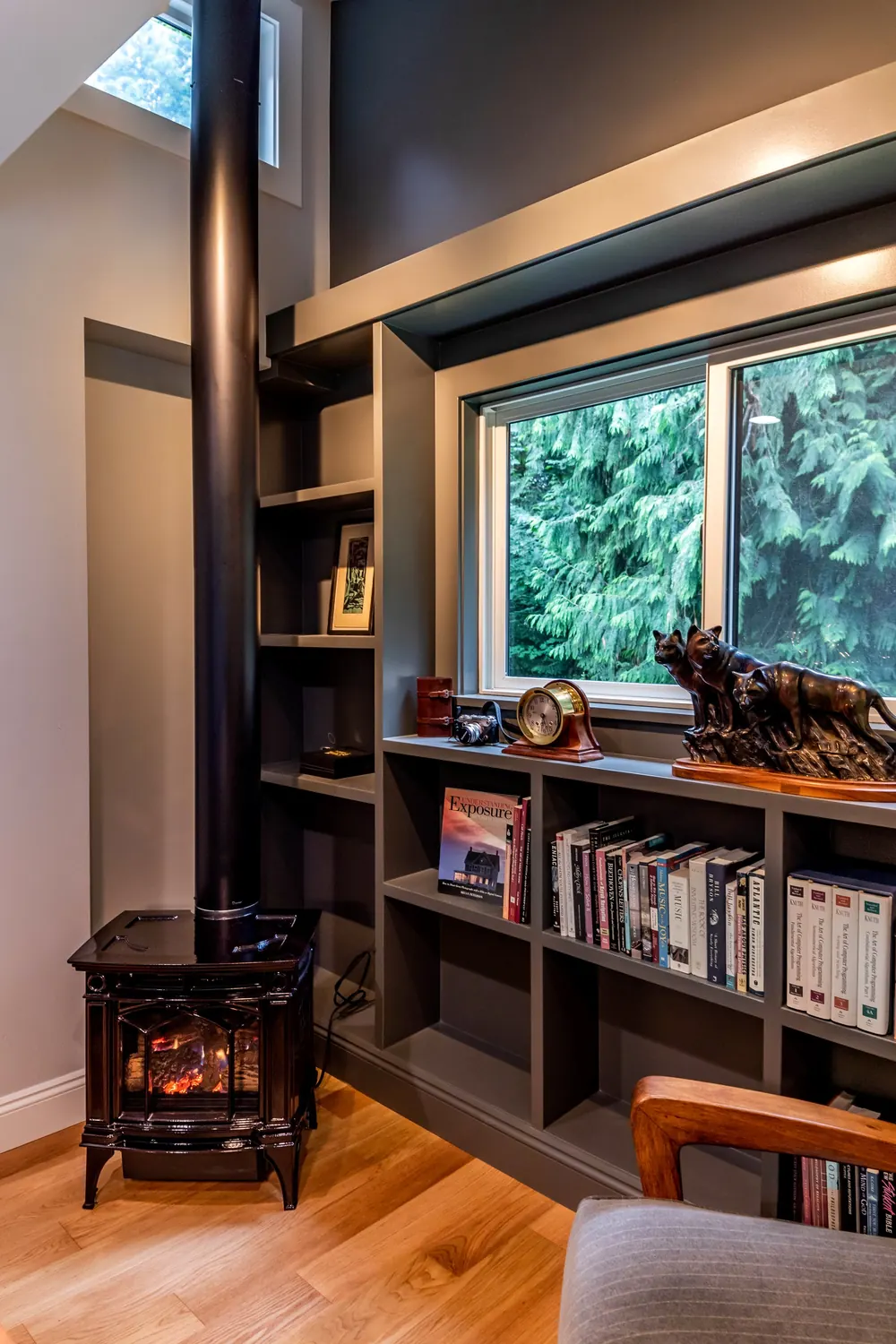 Dark built-in shelving beside a window