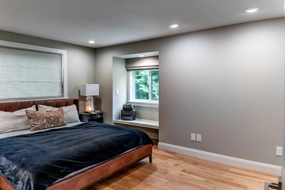 Bedroom with a window seat and dark bed