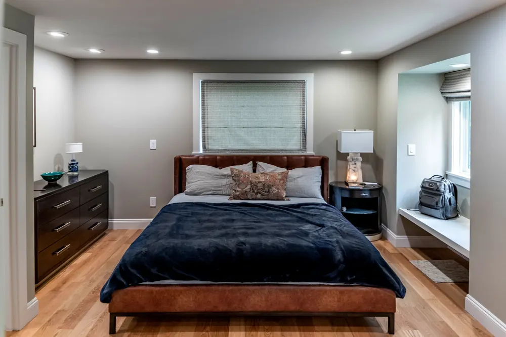 Bedroom with a dresser, lamps and window seat
