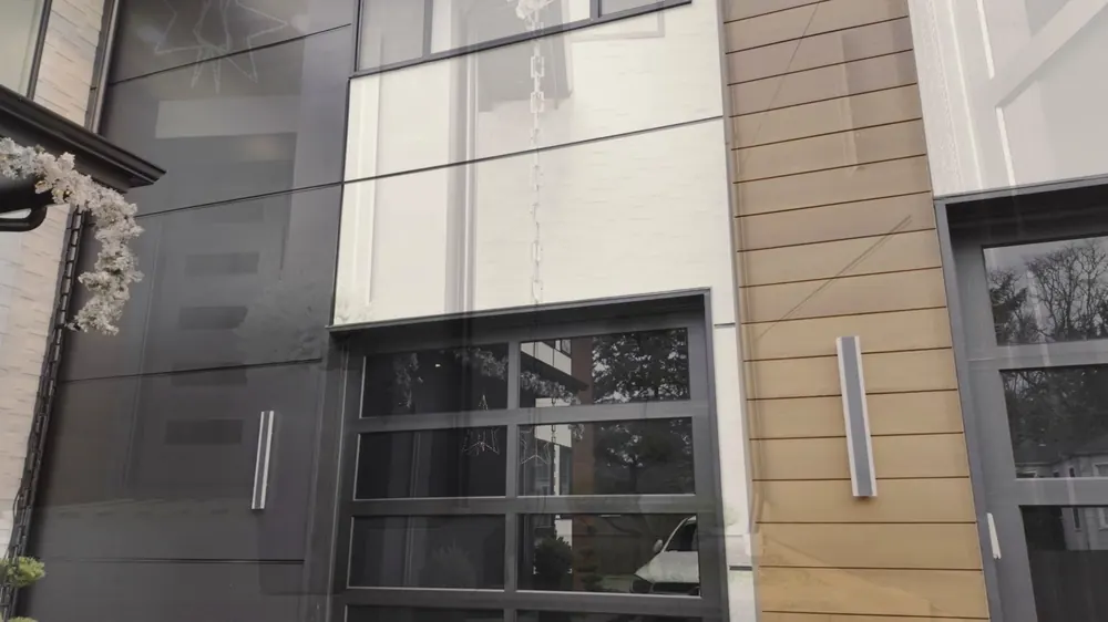 Facade detail with wood-look siding and a glass garage door