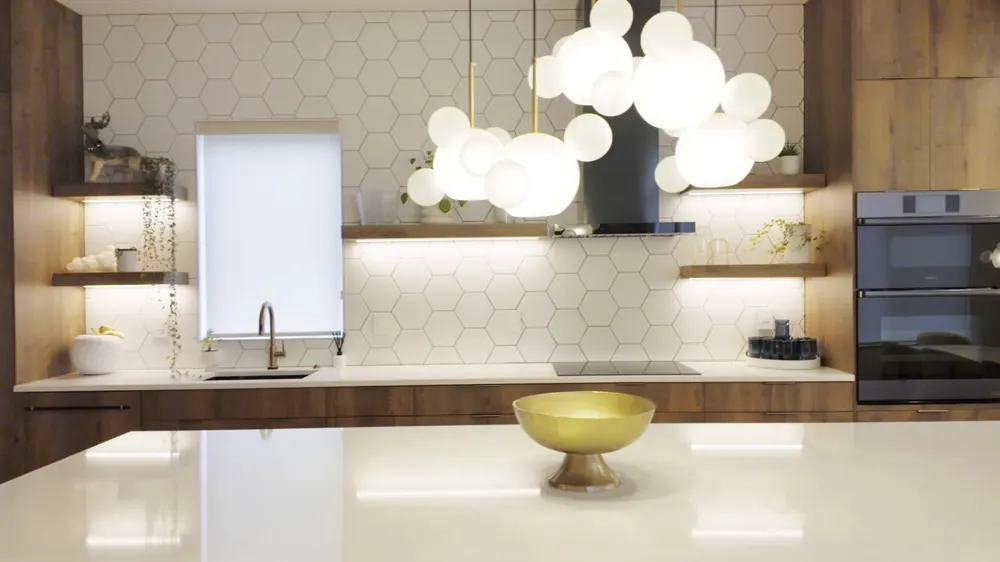 Kitchen island with wood cabinetry and globe pendants