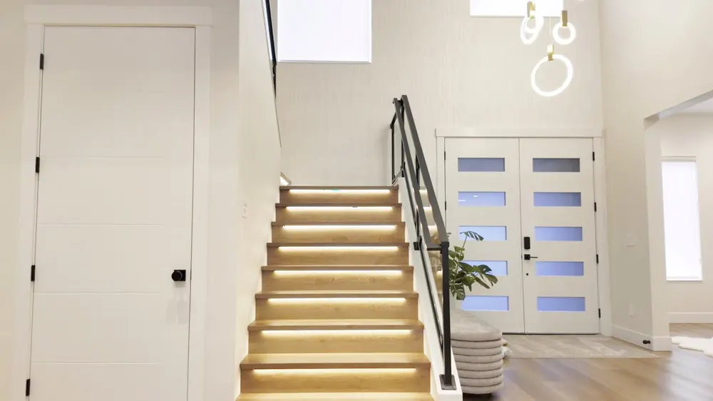 Entry with a lit staircase and glass front door