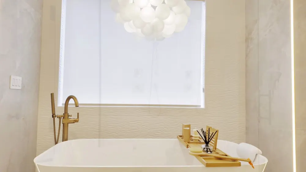 Freestanding tub with a gold floor-mounted filler