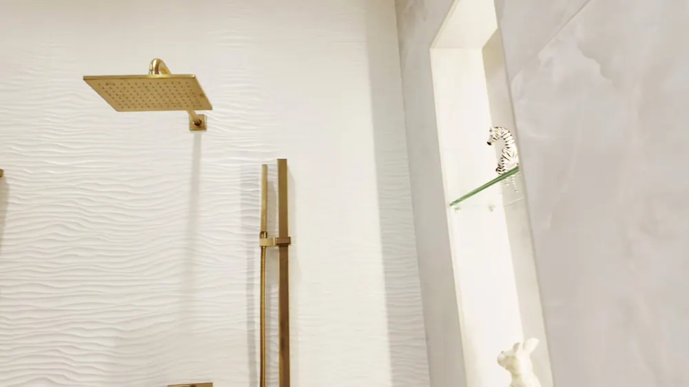 Gold shower valve and fixtures on a wave-texture panel