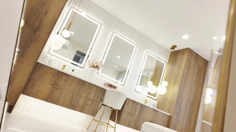 Double vanity with three lit mirrors